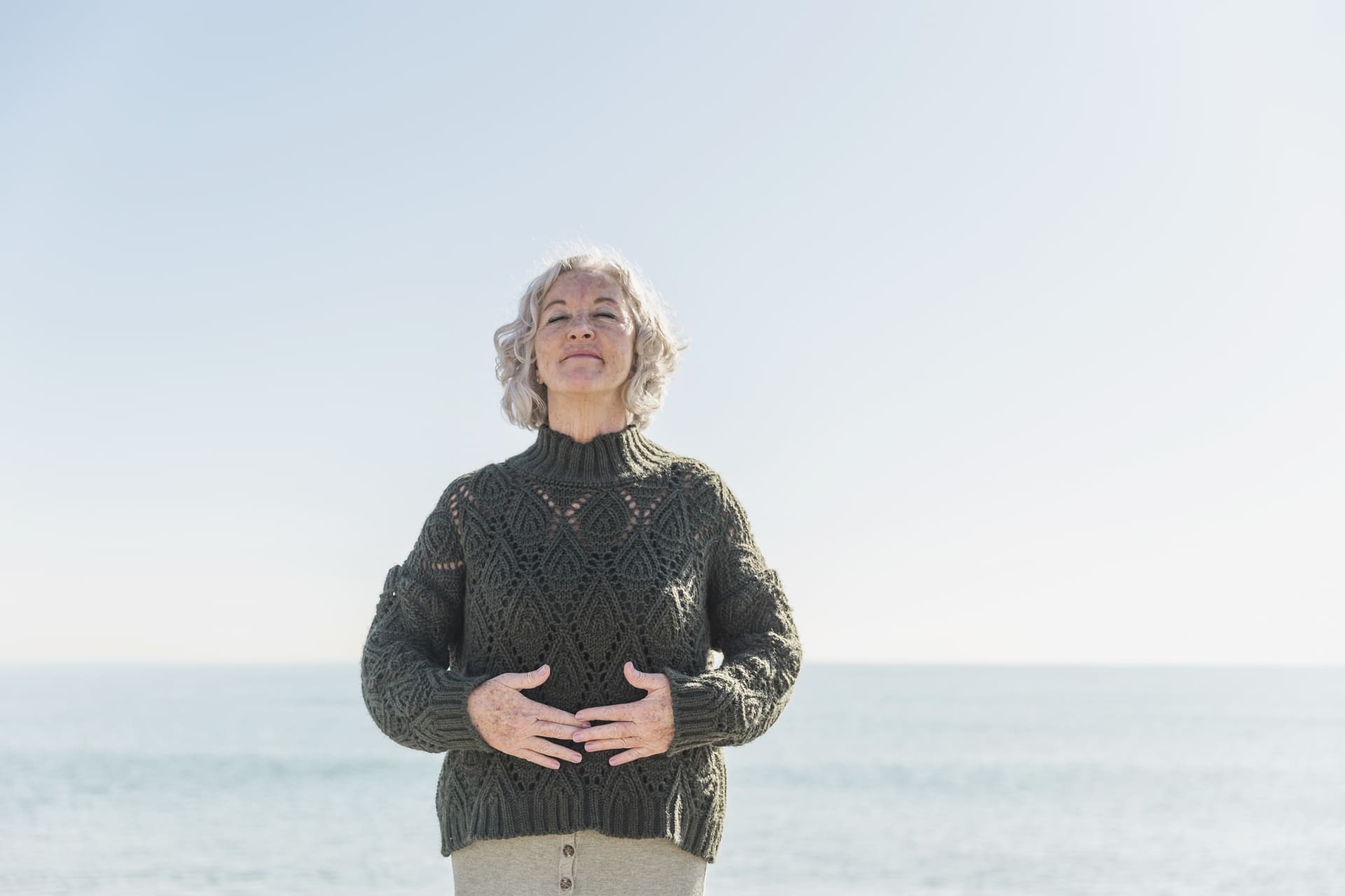 donna-anziana-di-vista-frontale-con-gli-occhi-chiusi-sulla-spiaggia